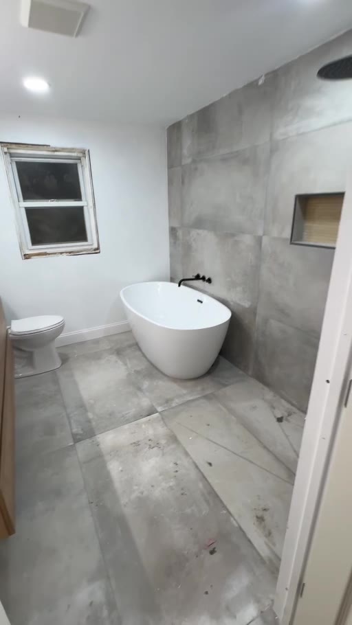 Bathroom with freestanding tub and large-format tile